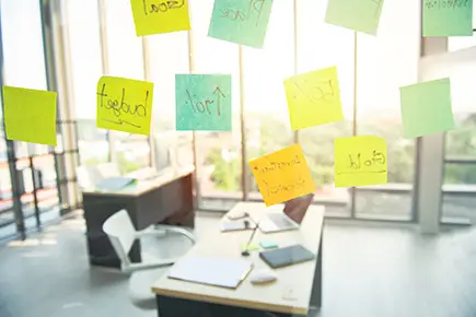 Helles Büro mit einer Glaswand voller Post-its mit Ideen